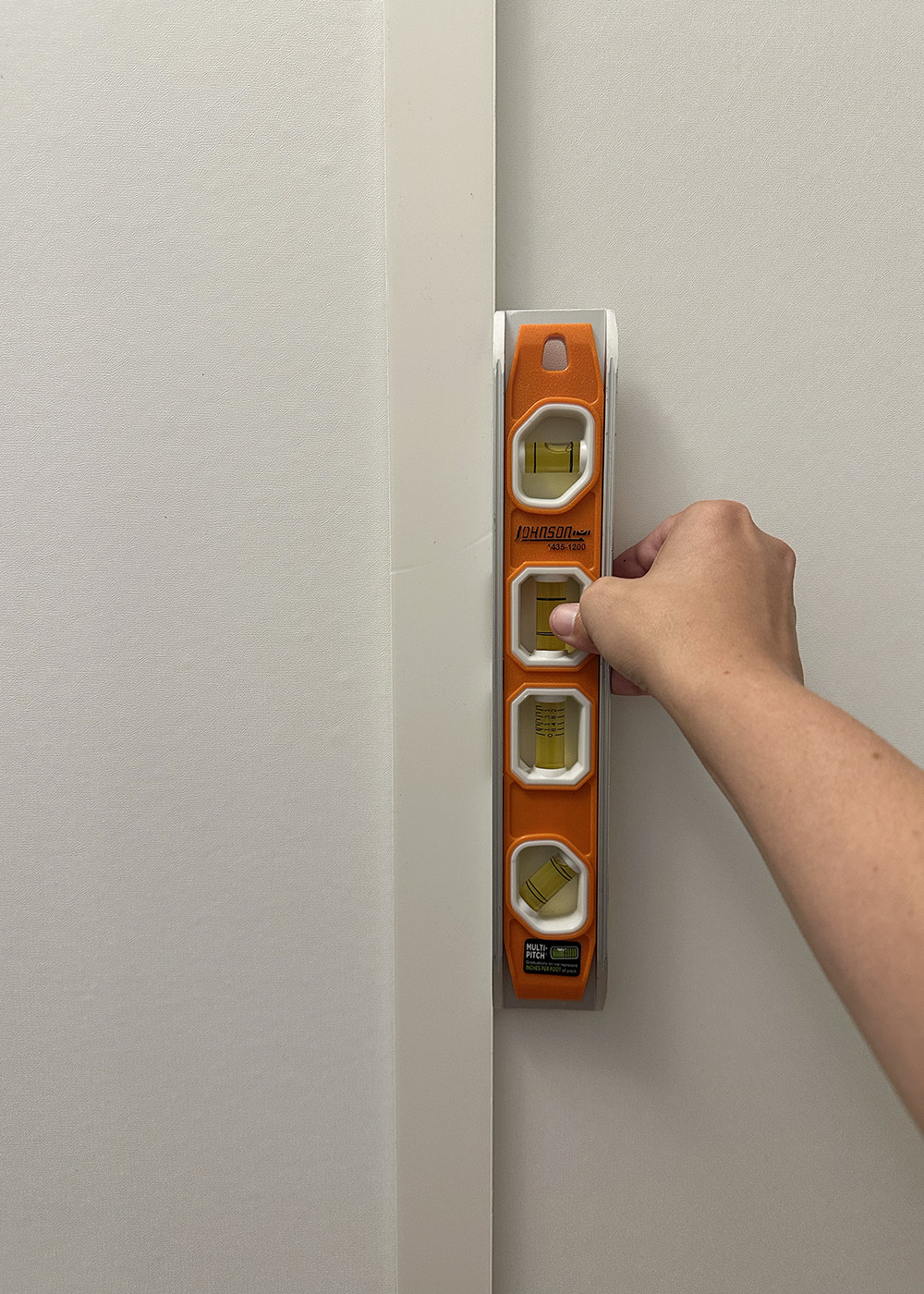 level | Tag and Tibby Attach pvc molding to the wall using hanging strips and a level | how to make faux board and batten